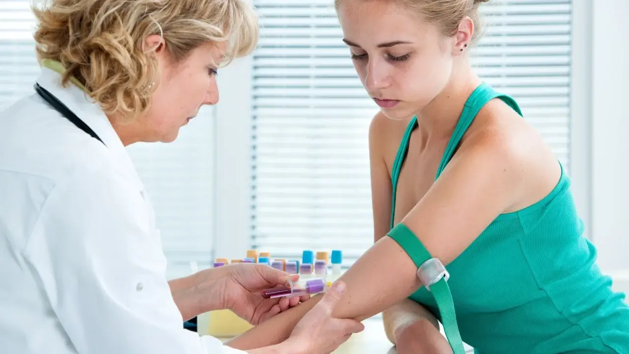 Pielęgniarka pobiera krew do badań. To część diagnostyki, która pomaga odpowiedzieć na pytanie: jonogram co to jest i jakie są jego wyniki.