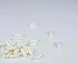 Białe kapsułki leżą na białym tle. Czy to suplement, czy anapran na co?