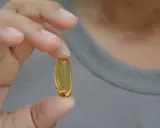 Dłoń trzyma kapsułkę z olejem. Zastanawiasz się nad omega-3 6 9 skutki uboczne?