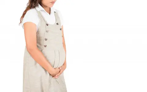 Kobieta w ciąży, trzymająca się za brzuch, może odczuwać dyskomfort związany z infekcją intymną.