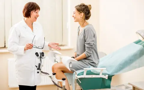 Lekarka uspokaja pacjentkę przed badaniem. Czy cytologia boli? Lekarka wyjaśnia, że nie musi.