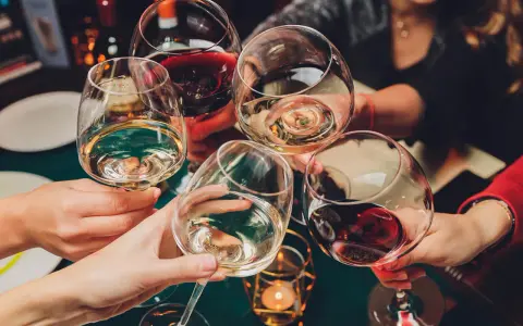 Ludzie wznoszą toasty winem. Pamiętaj o odpowiedzialnym spożywaniu alkoholu, zwłaszcza gdy rozważasz antykoncepcję.