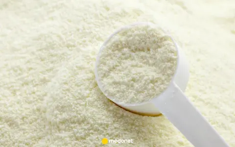 Biały proszek w miarce na tle sypkiego produktu. Czy protifar ma skutki uboczne?
